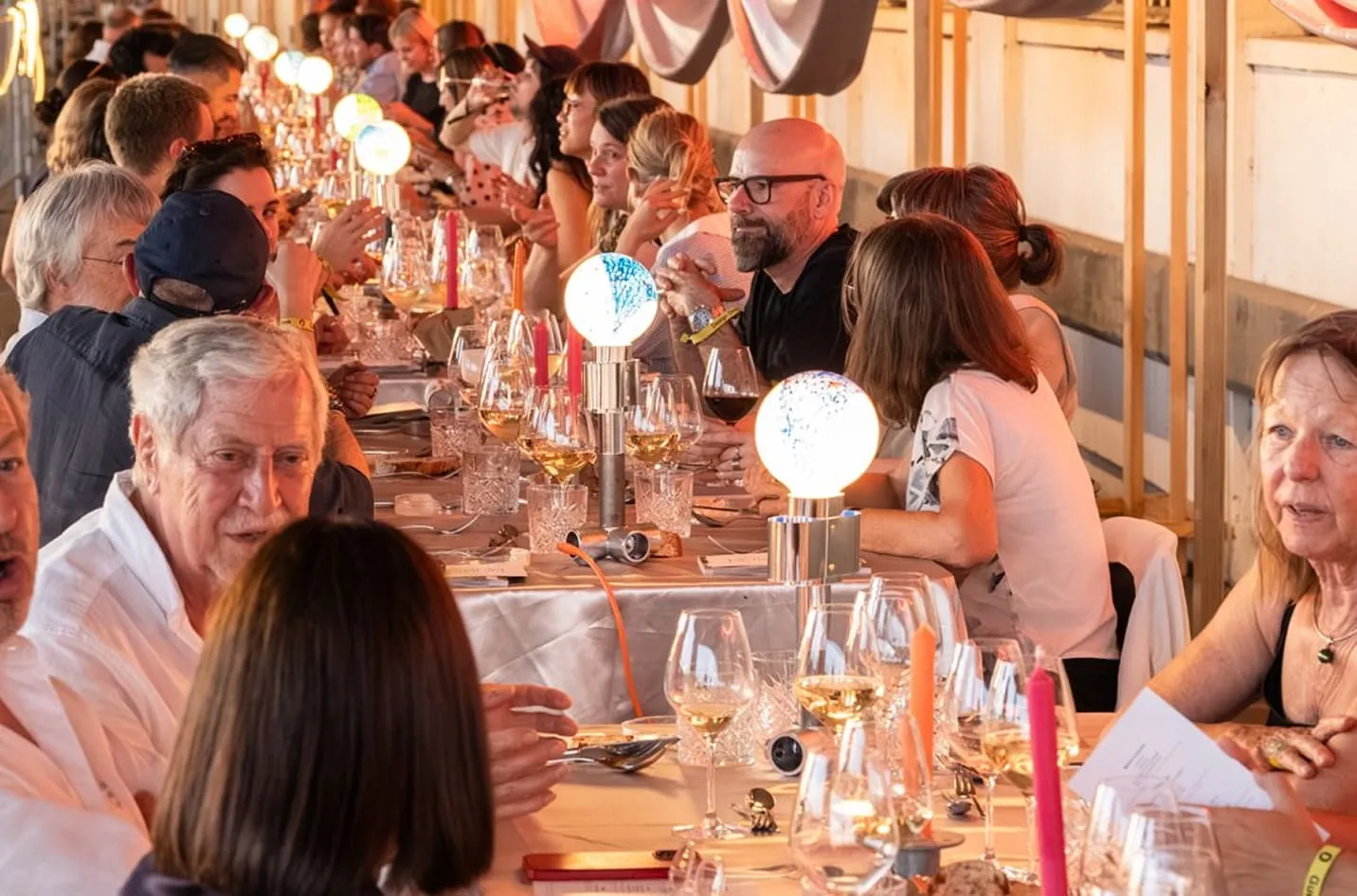Convives attablé·e·s au Design Dinner, entre verres de vin et lampes Pisoni–lab