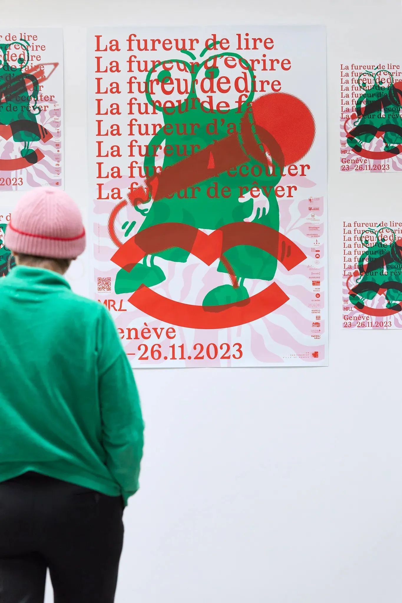 Une personne debout devant un mur avec des affiches sur lui

[Note: The text "sur" in French means "on", but in this context, it is used to indicate location, so I translated it as "with".]