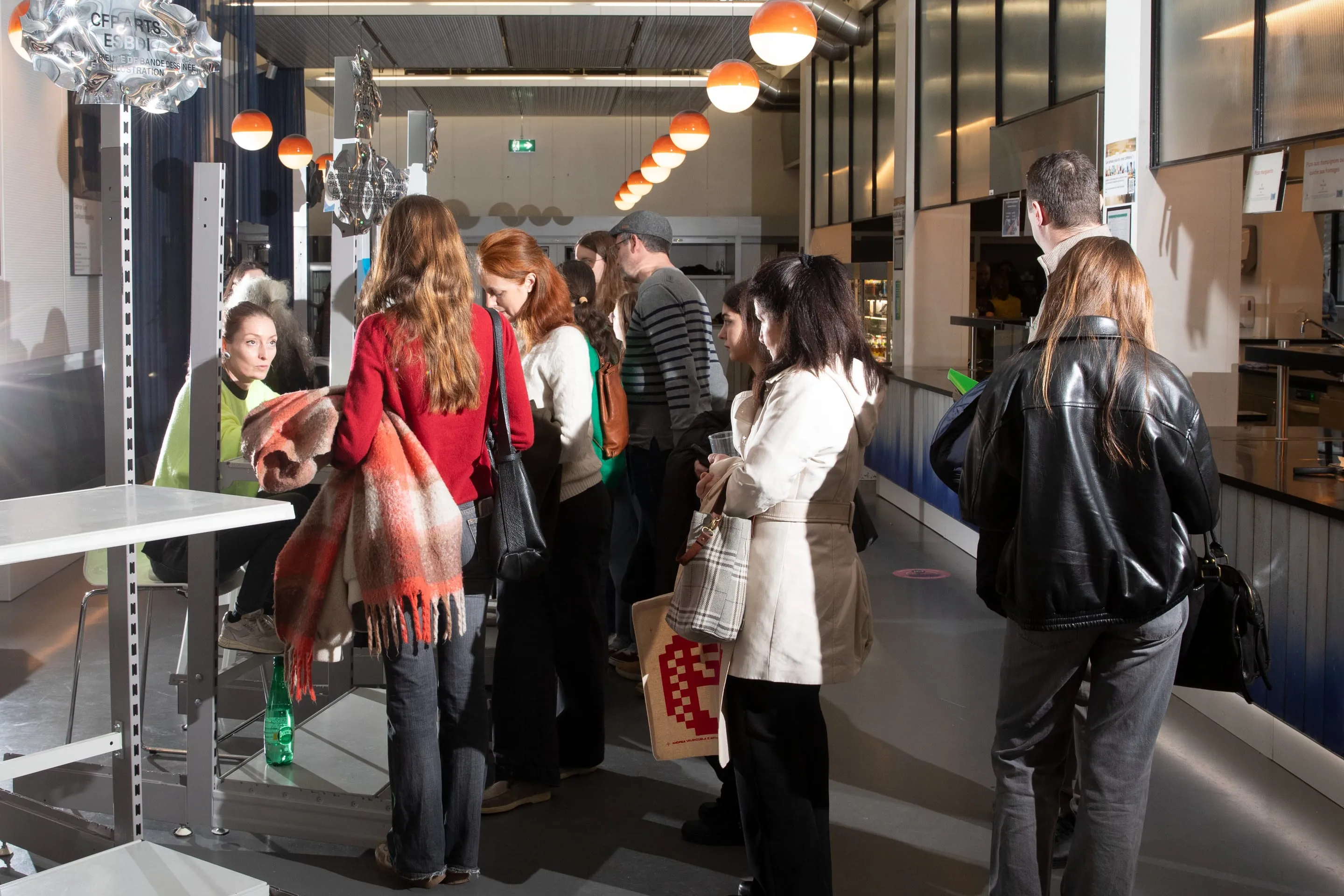File d'attente sous les mobiles suspendus à face miroir, Portes ouvertes HEAD 2026