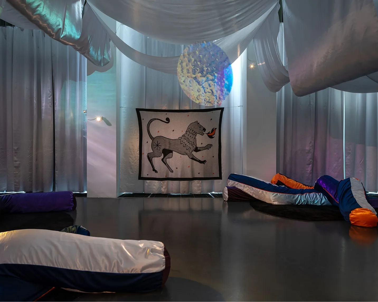 Une pièce remplie de nombreux coussins et d'une peinture sur le mur