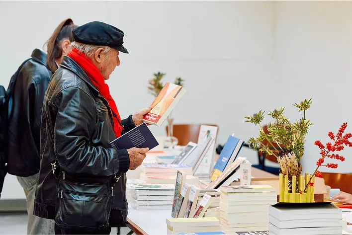 A man standing in front of a table filled with books