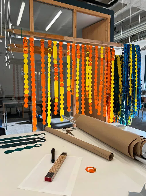 A table with a roll of construction paper and a pair of scissors