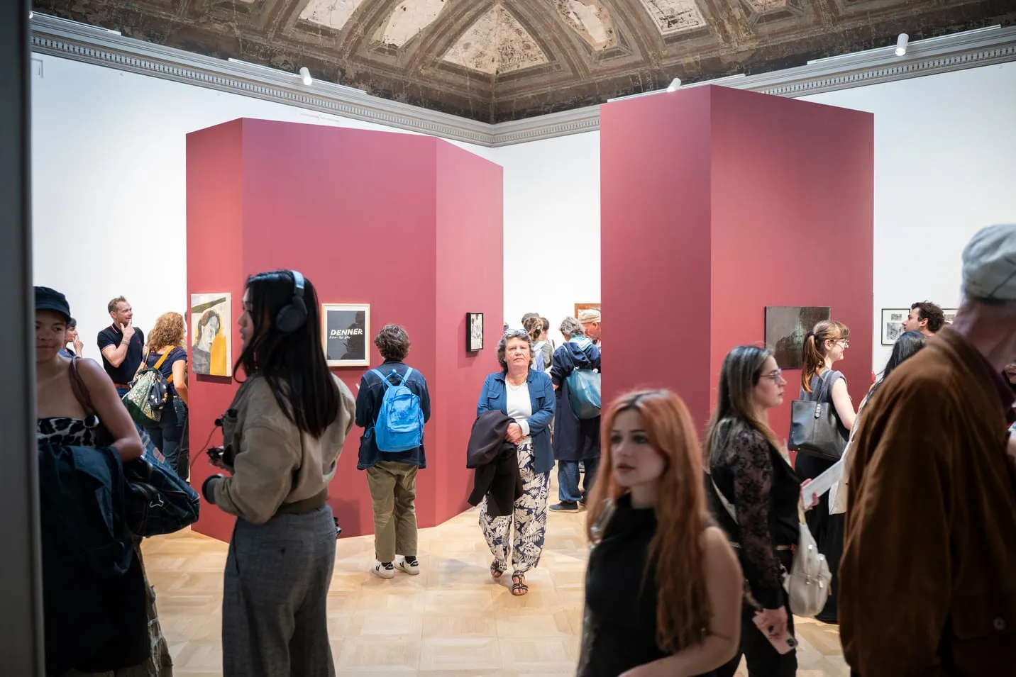 Public du vernissage entre les volumes rouge bordeaux de la salle Saint-Ours