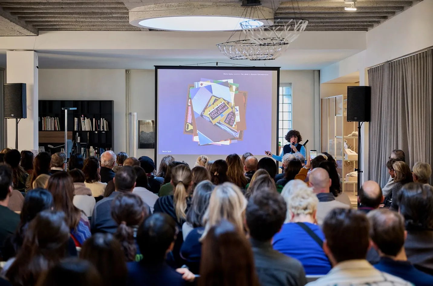 Intervenante présentant au Pecha Kucha FOODDD devant le public, showroom Teo Jakob à Genève