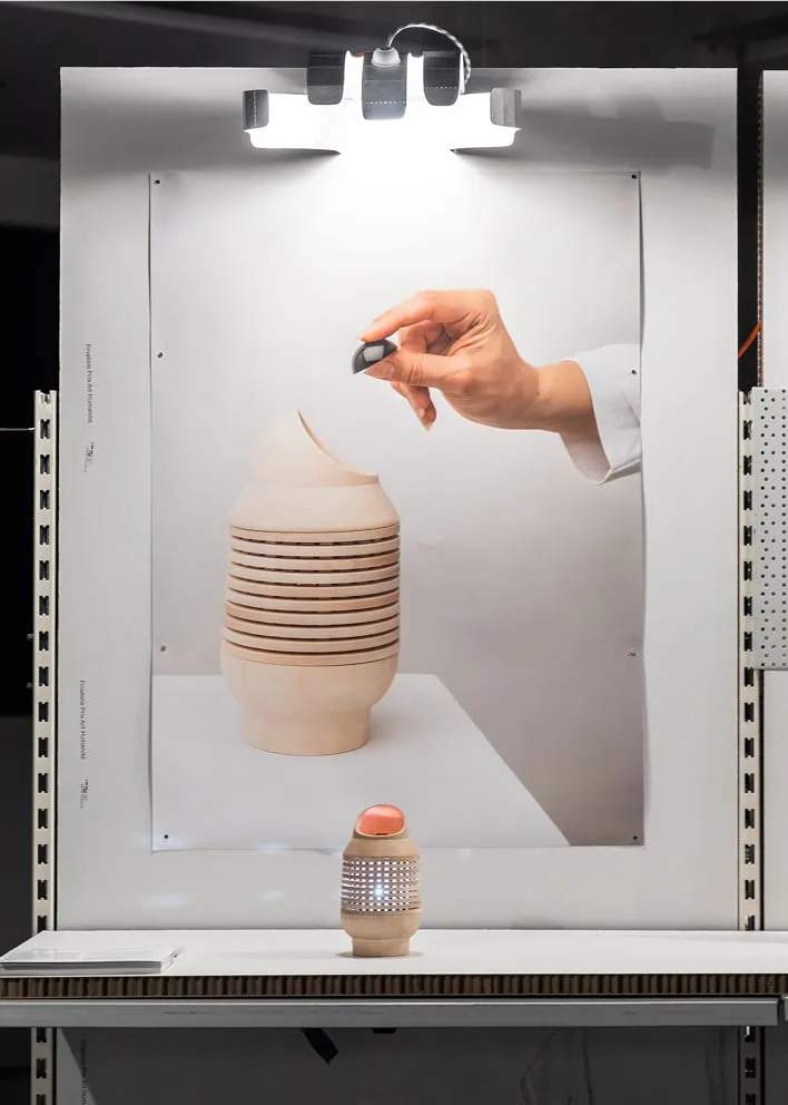 Une personne tient un stylo devant une photographie d'une pile de plats superposés