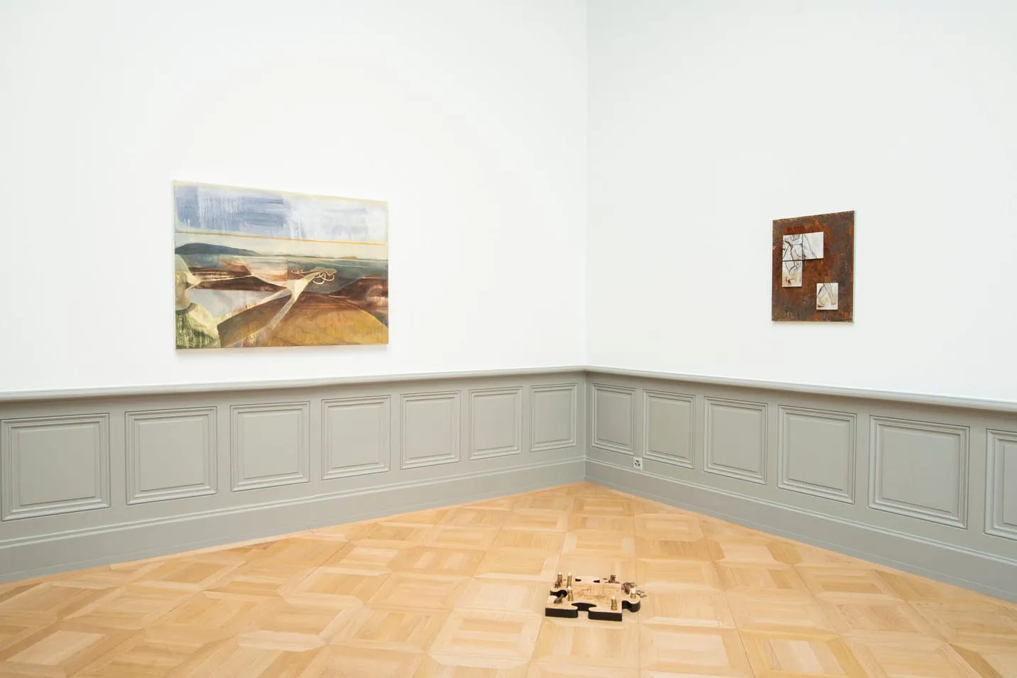 Peinture de paysage et œuvre sur métal au mur, pièce posée au sol