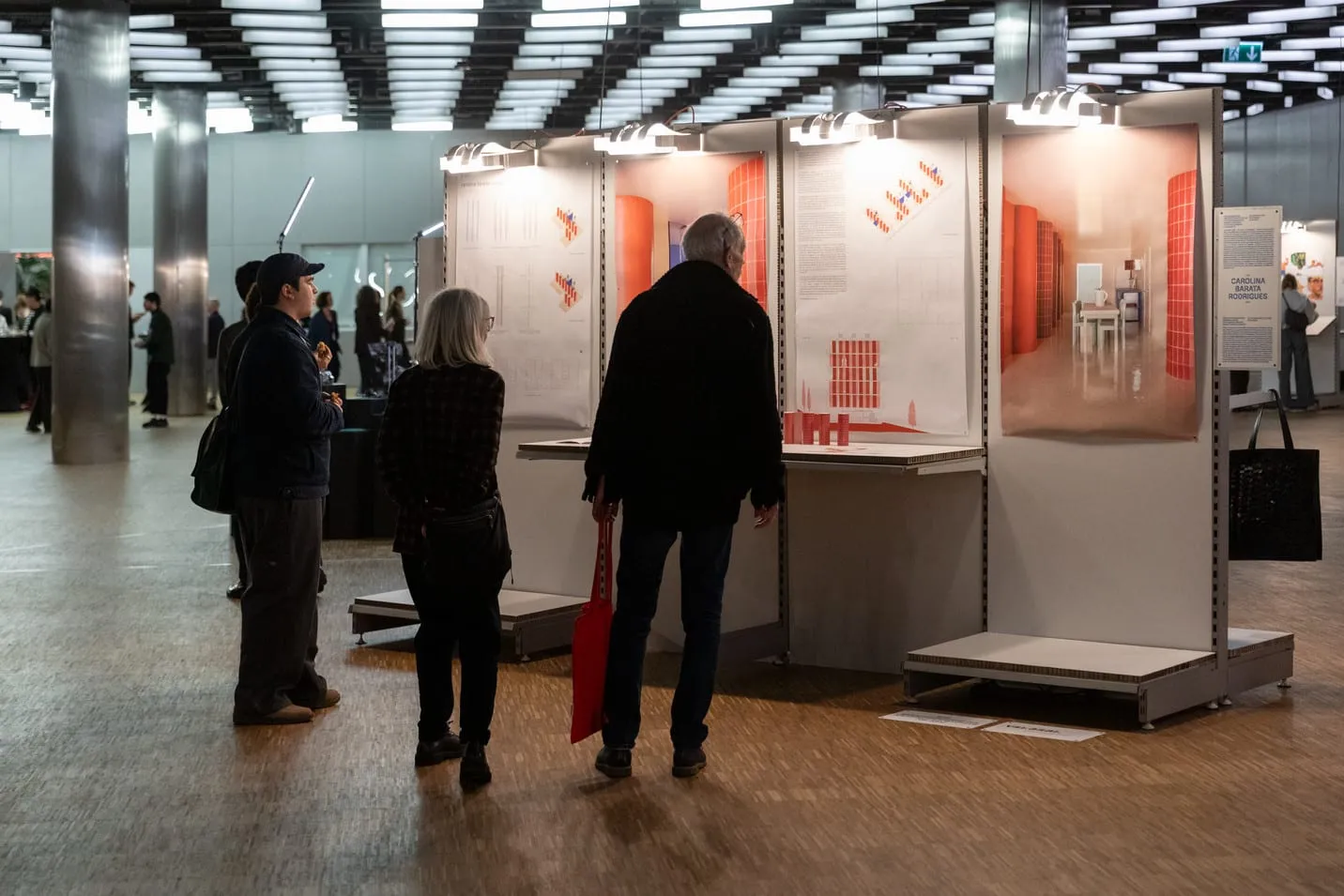 Visitors at modules displaying orange-toned images.
