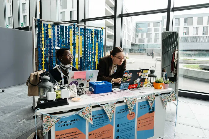 A couple of people sitting at a table with laptops