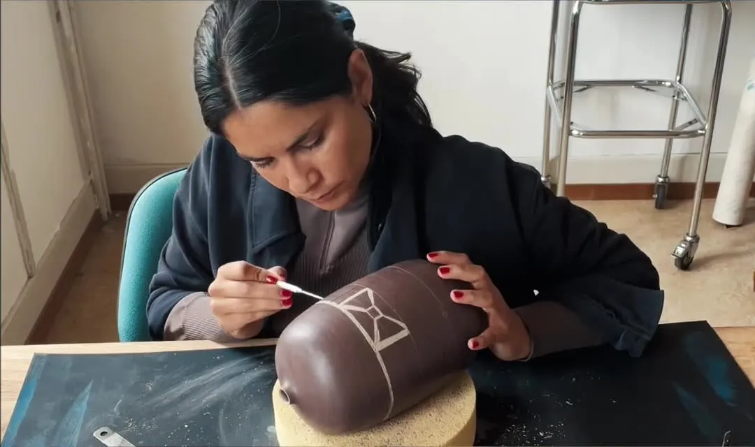 Karen Pisoni grave le décor en sgraffito sur un vase de Théo Heritier
