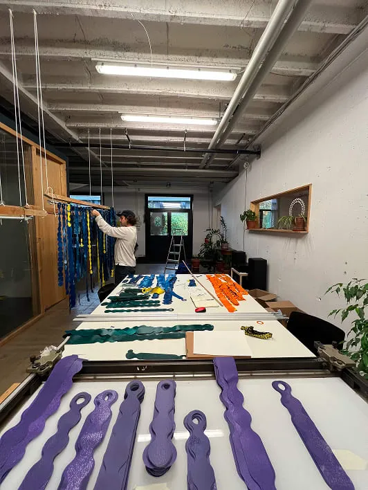 A man standing over a table filled with purple scissors