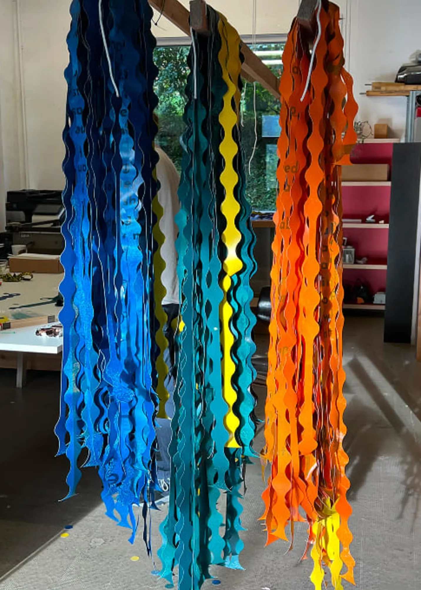 Rideaux modulaires bleus et orange terminés, suspendus en atelier