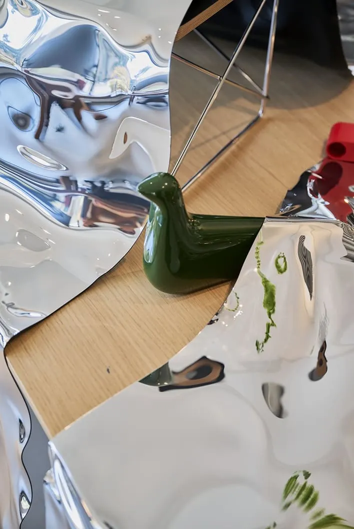 Oiseau en céramique verte posé entre deux surfaces miroir thermoformées