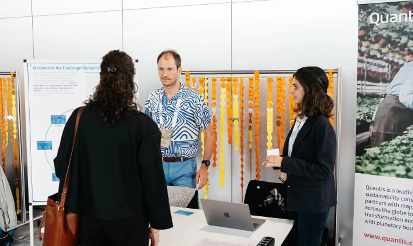 Conversation in front of a booth, orange modular curtain behind