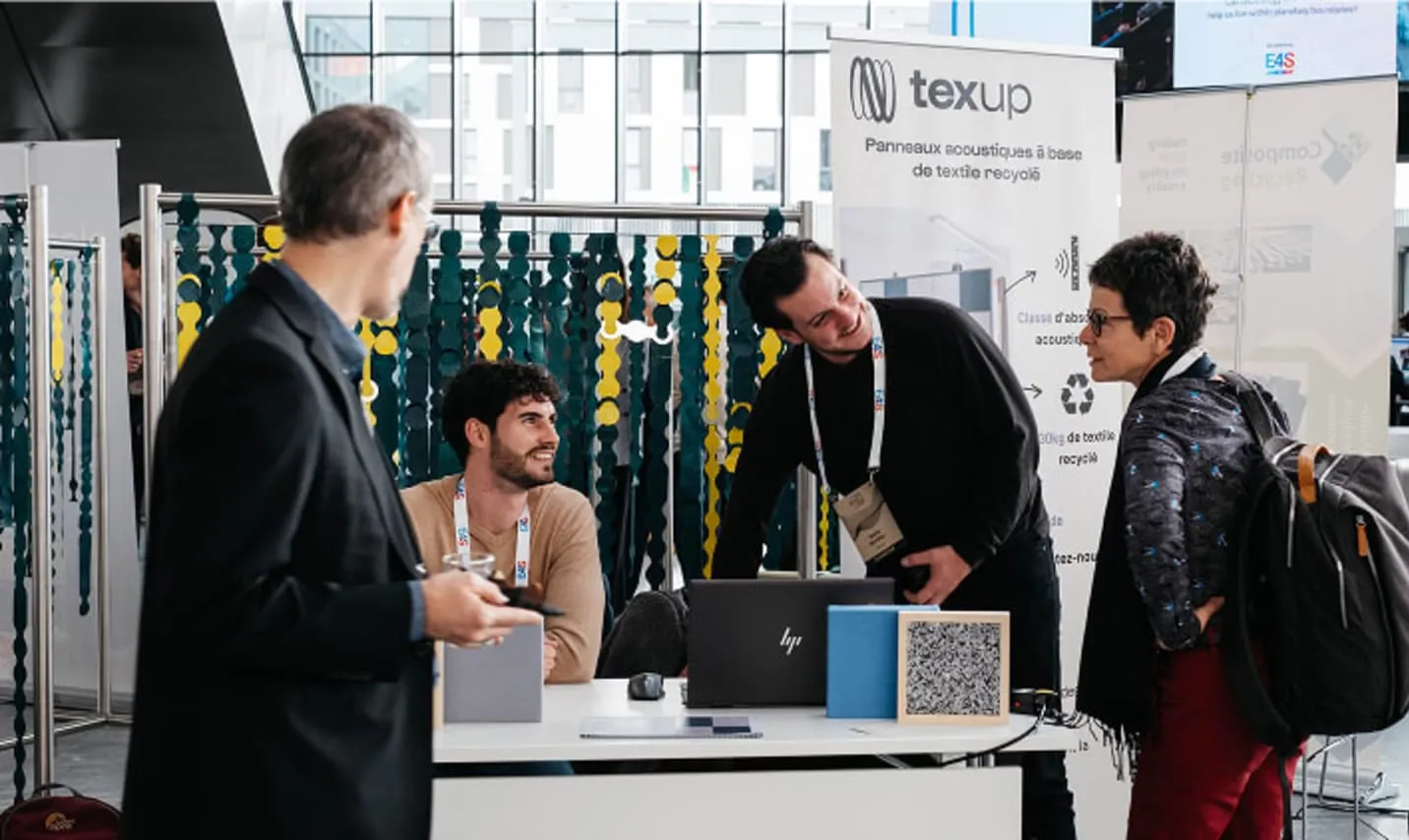 Discussion at a startup booth, modular curtains in the background