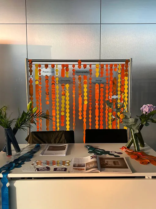 A white desk topped with a computer monitor and a vase filled with flowers