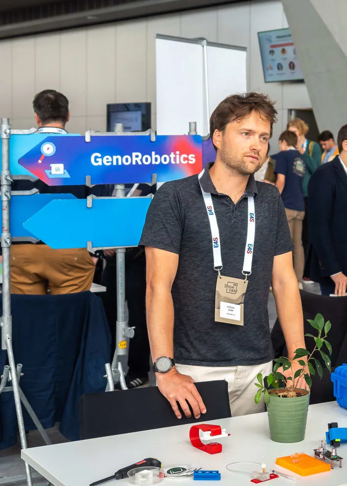 Reused road sign bearing the GenoRobotics name, on a stand