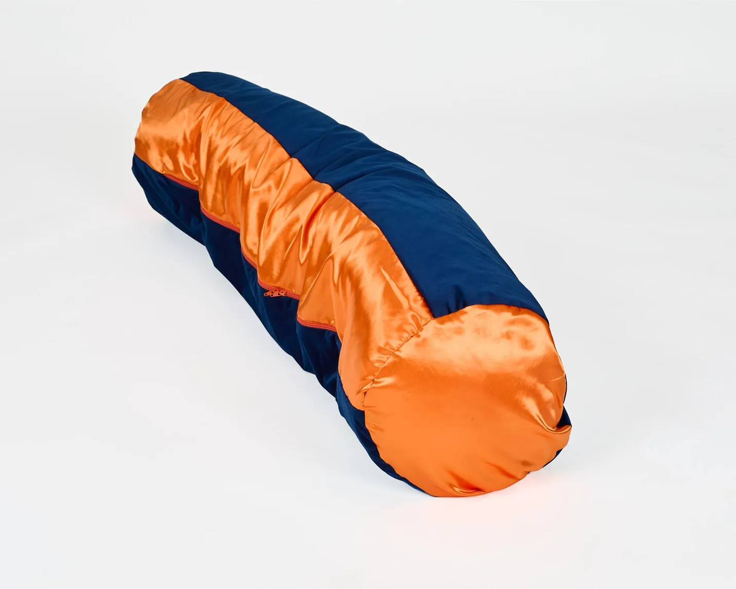 Un grand coussin en forme de tube sur fond blanc