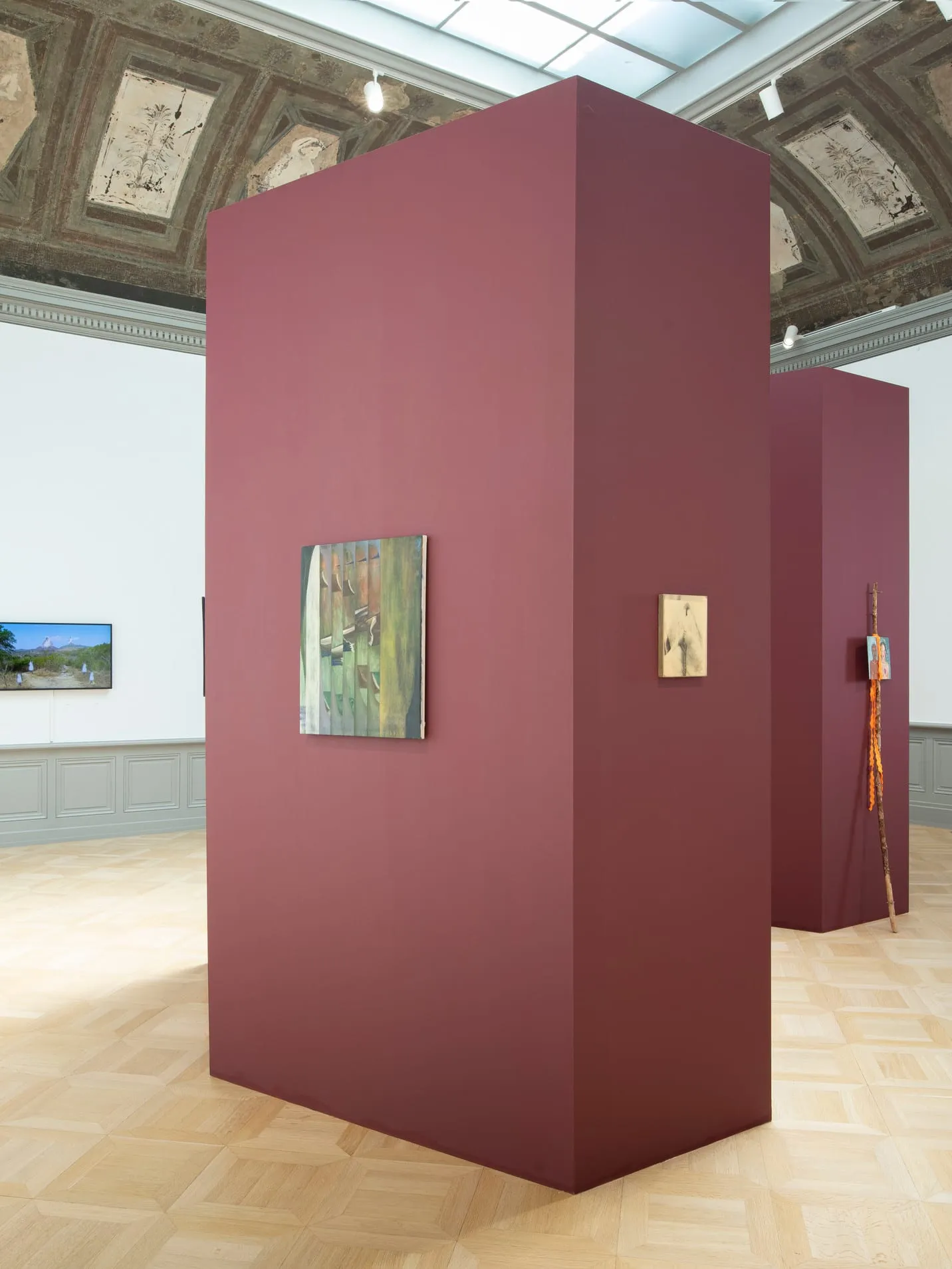 Volume en bois peint en rouge bordeaux, avec peinture et sculpture, sous le plafond peint