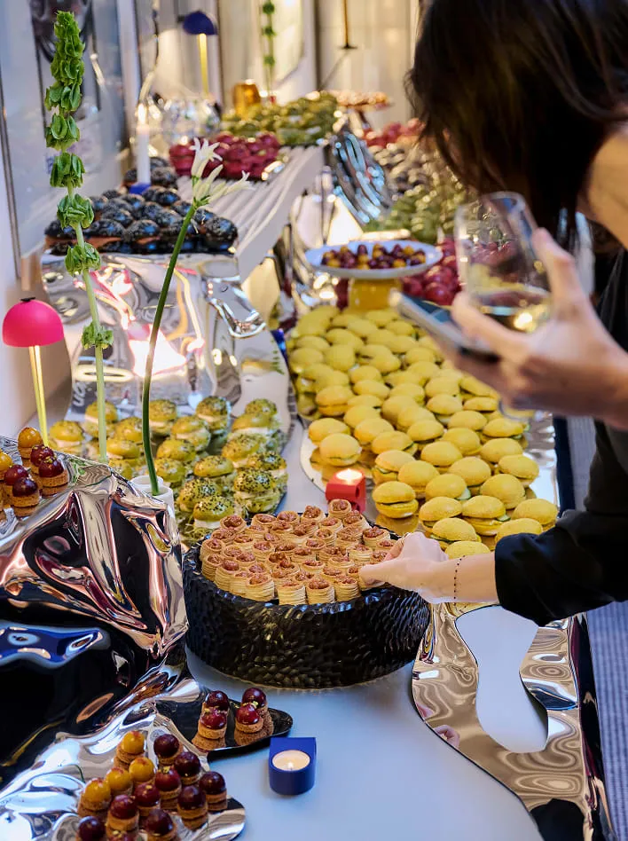 Invitée prenant une bouchée au buffet de macarons et tartelettes