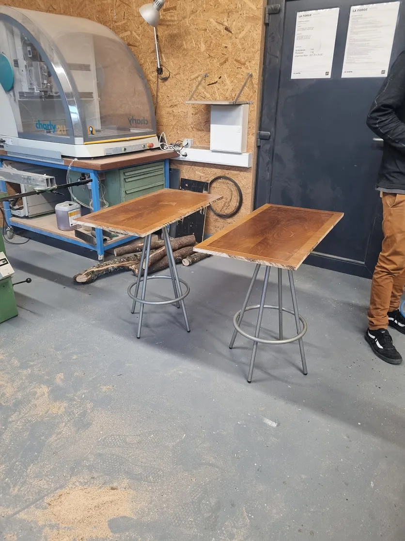A man standing next to a wooden table