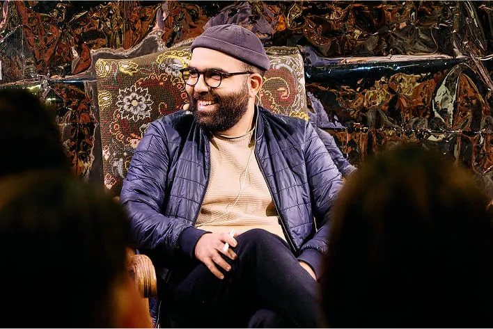 A man sitting in a chair with a beard