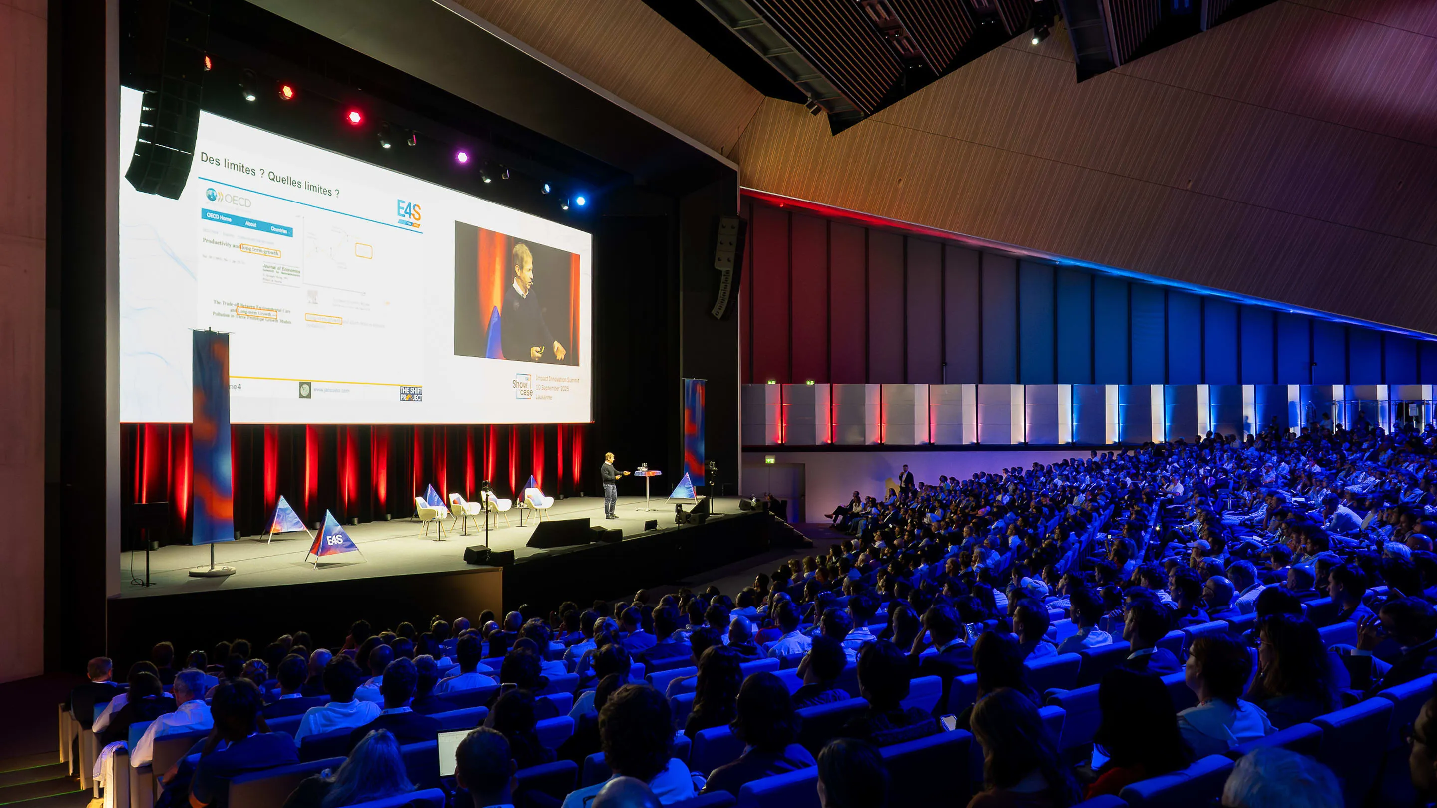 Full plenary hall facing the stage with triangles, Showcase E4S 2025