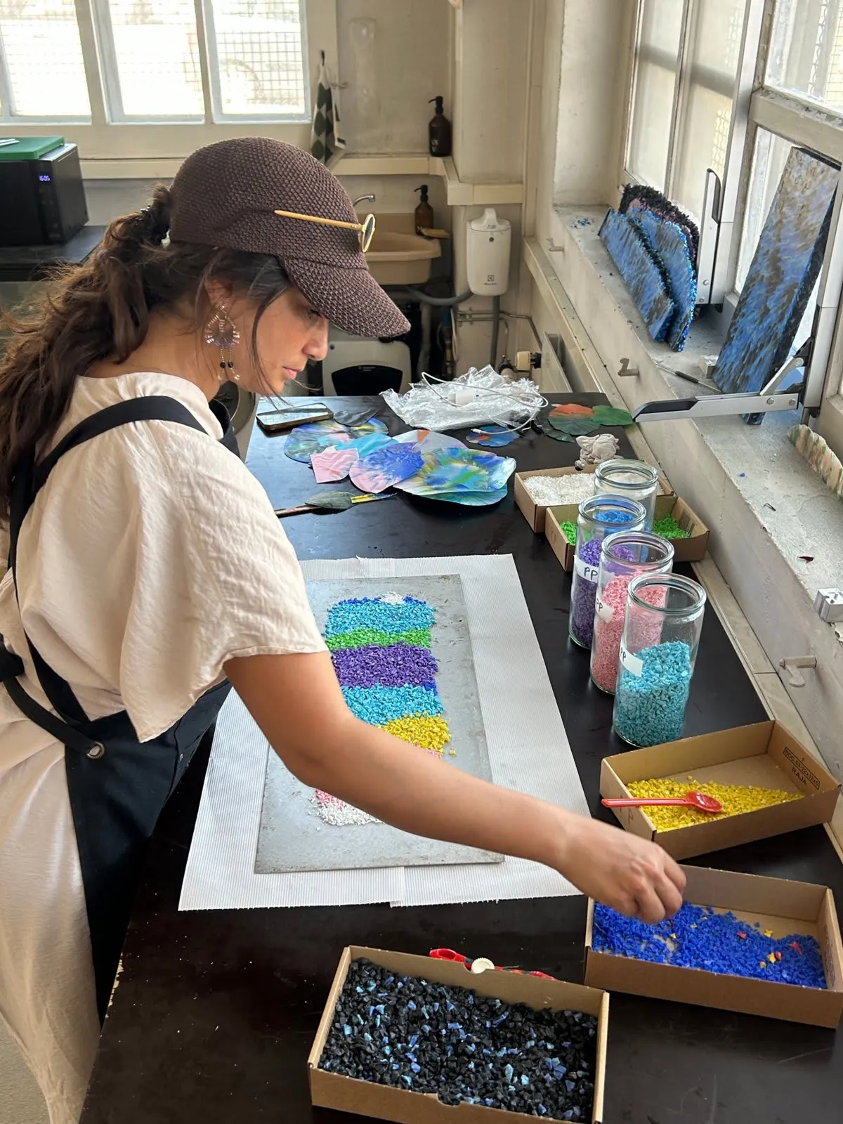 Karen Pisoni sorting recycled plastic granules by colour at the Glitter workshop in Geneva.