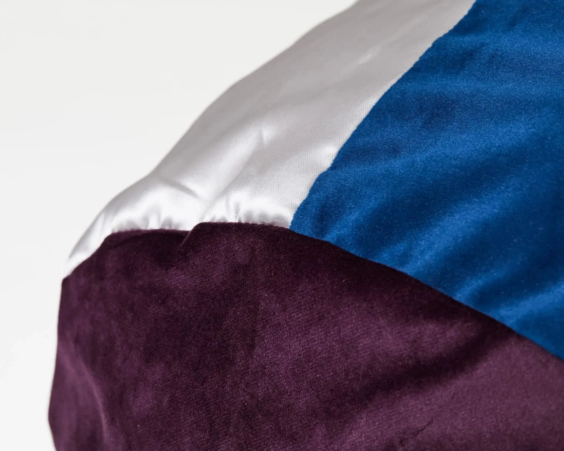 détail coussin rond en tissus trois couleurs