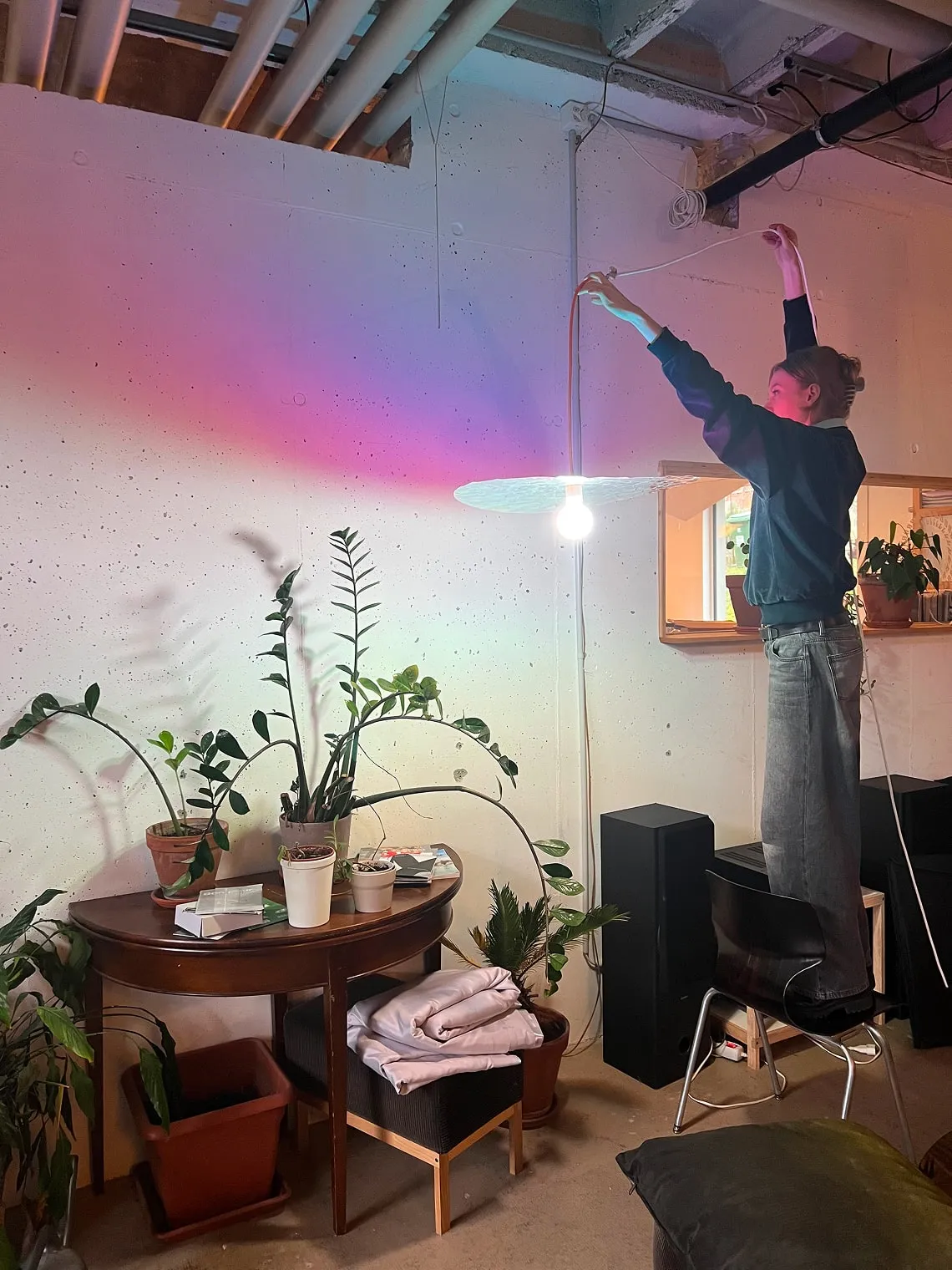 Un homme debout sur une chaise dans une pièce