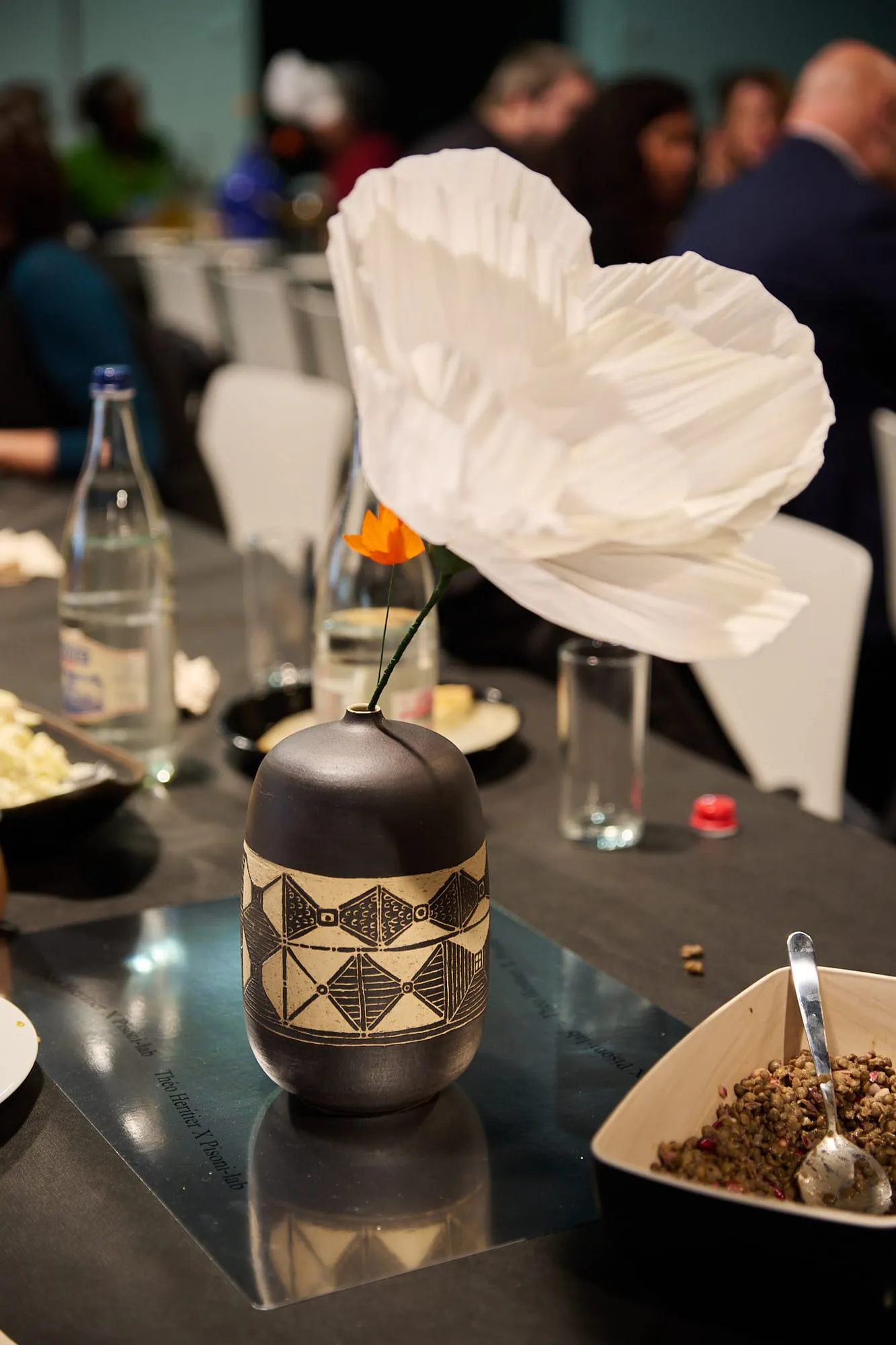 Vase Sgraffito sur une table du dîner du symposium ELIA, avec une fleur en papier de Studio Gala