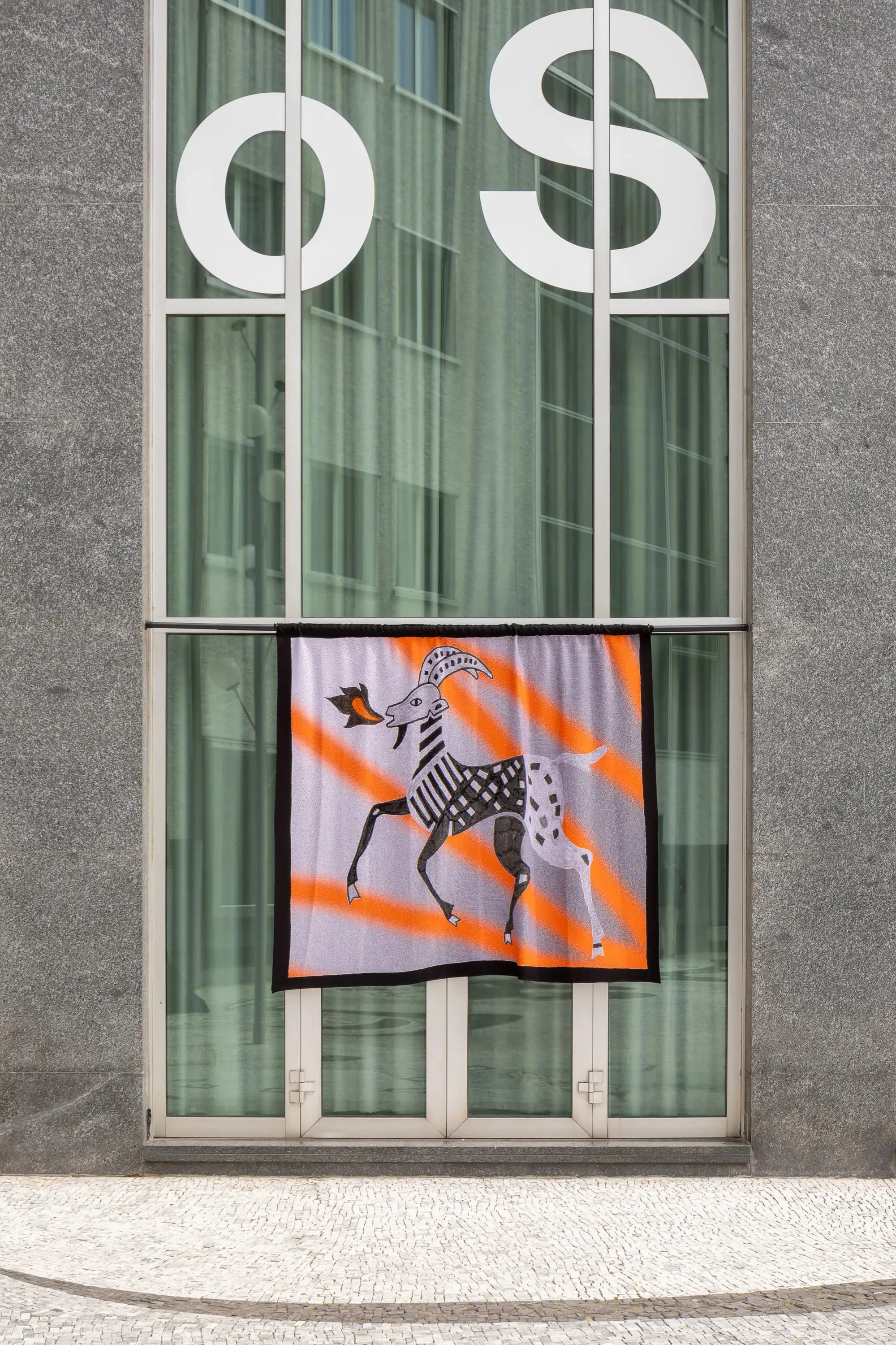 Une fenêtre avec un drapeau suspendu dedans